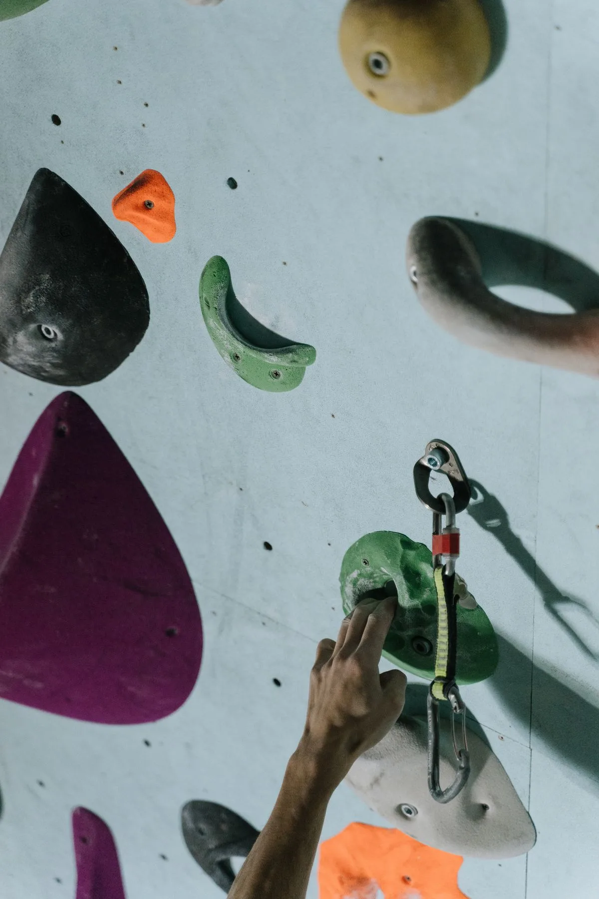 Main qui saisit une prise colorée sur un mur d'escalade