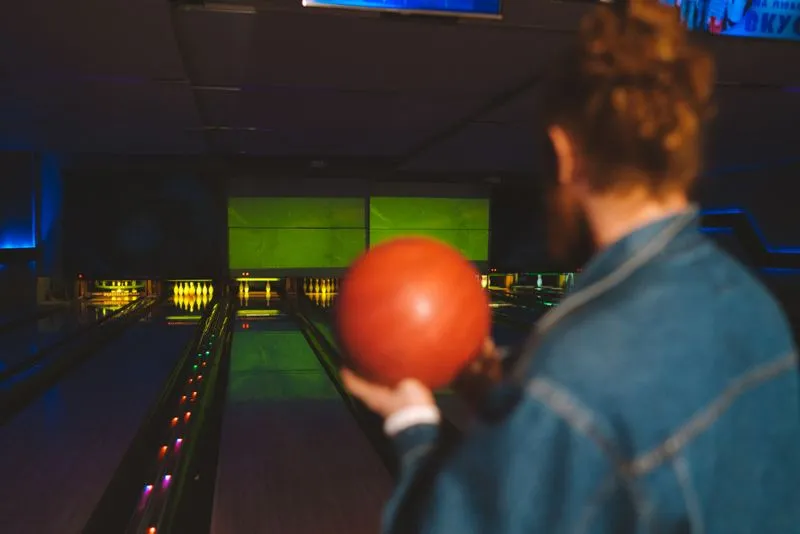 Joueur de bowling face aux pistes éclairées